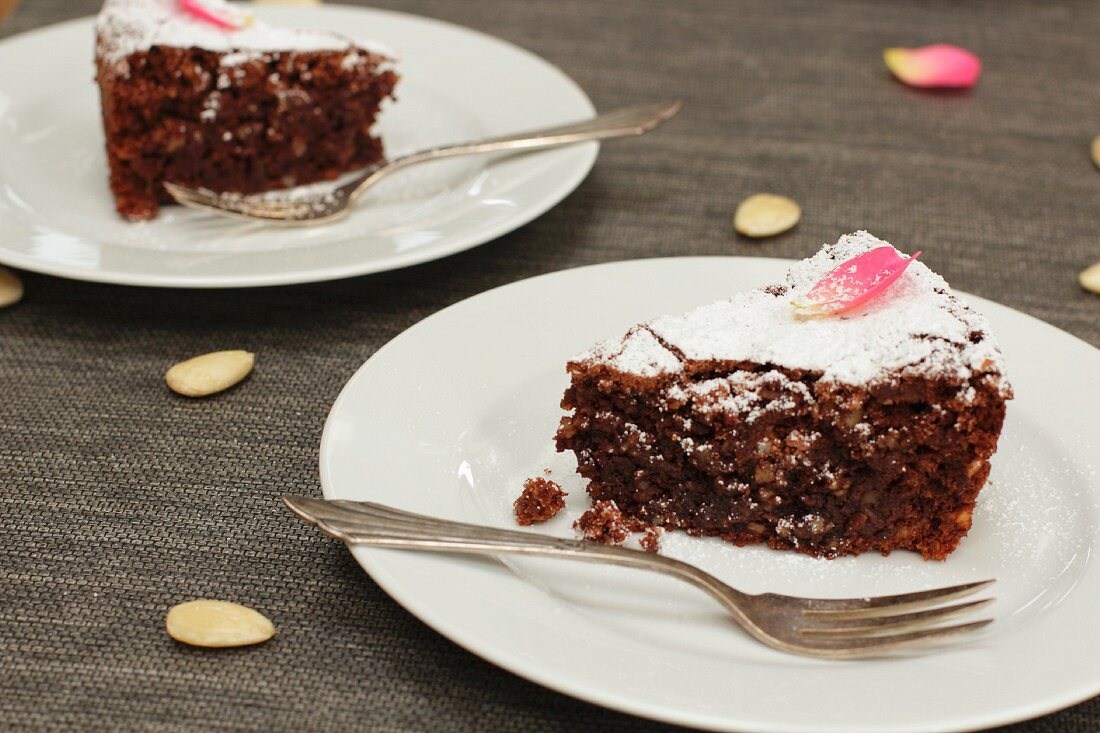 Zwei Stücke Mandelkuchen mit Schokolade auf Tellern (Italien)