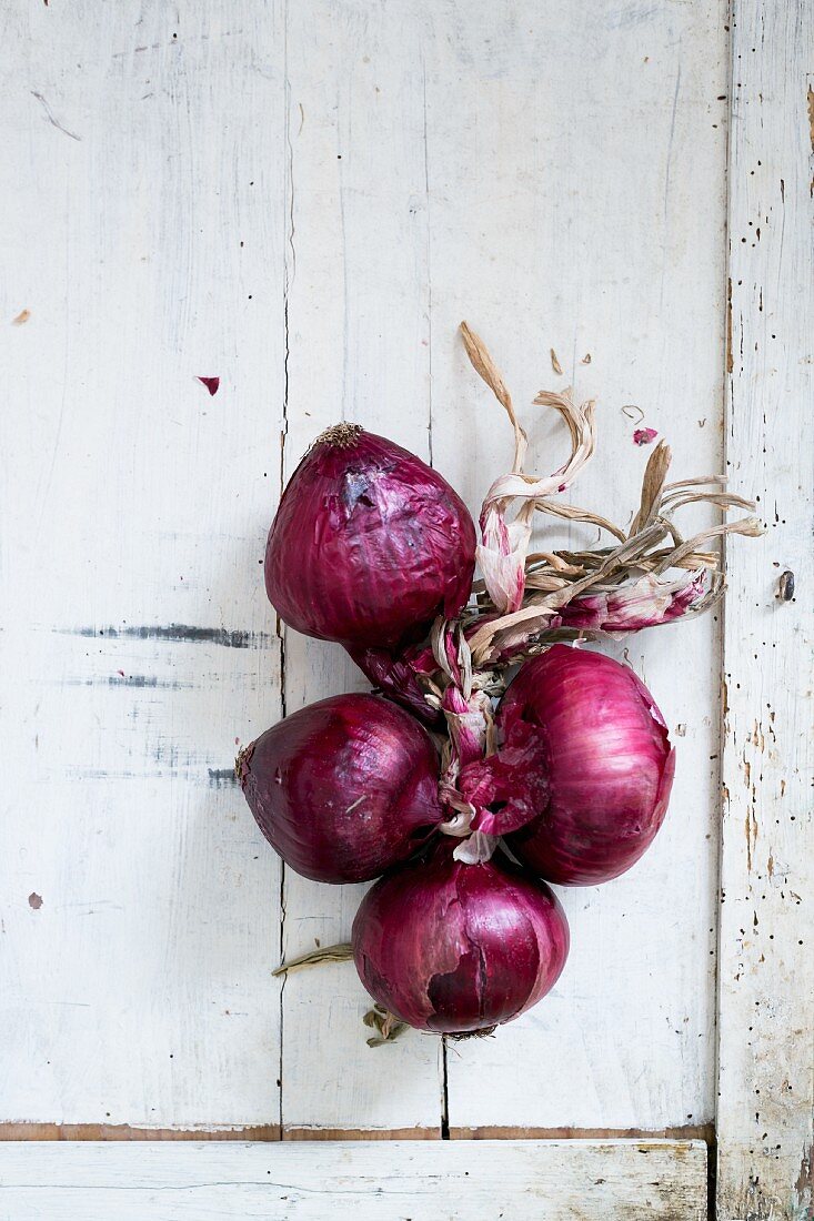Red onions on a white wooden table