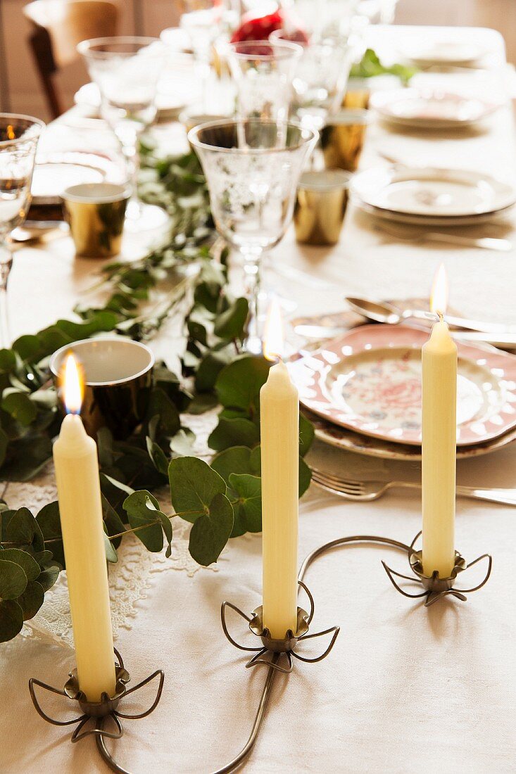 Delicate metal candle holder with floral motif on set table