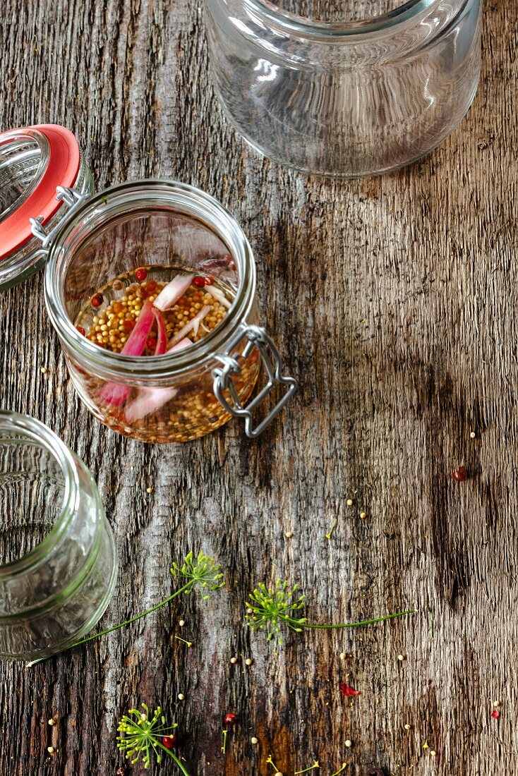 A vinegar preserving liquid in jars on a wooden surface