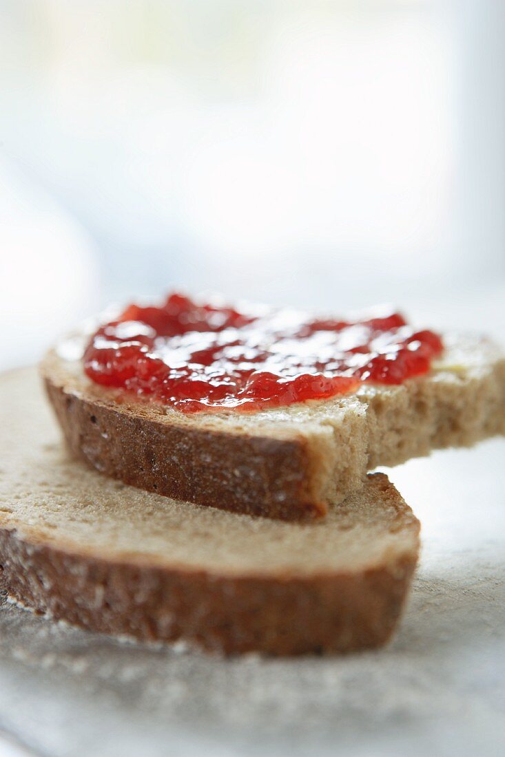 Slices of rye bread spread with jam with a bite taken out