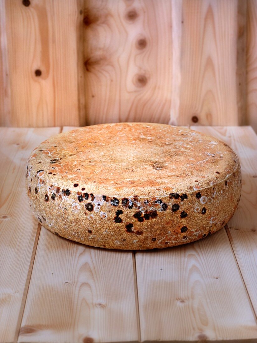 A wheel of cheese on a wooden board (Vogesen, Alsace)