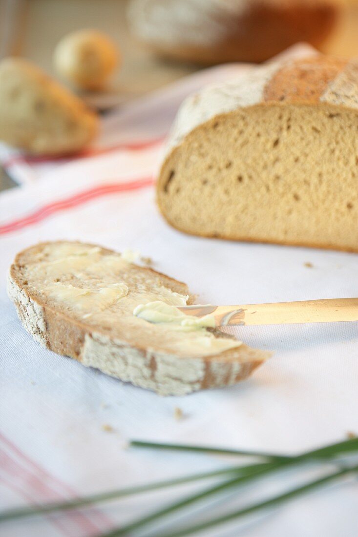 Kartoffelbrotscheibe, mit Butter bestrichen