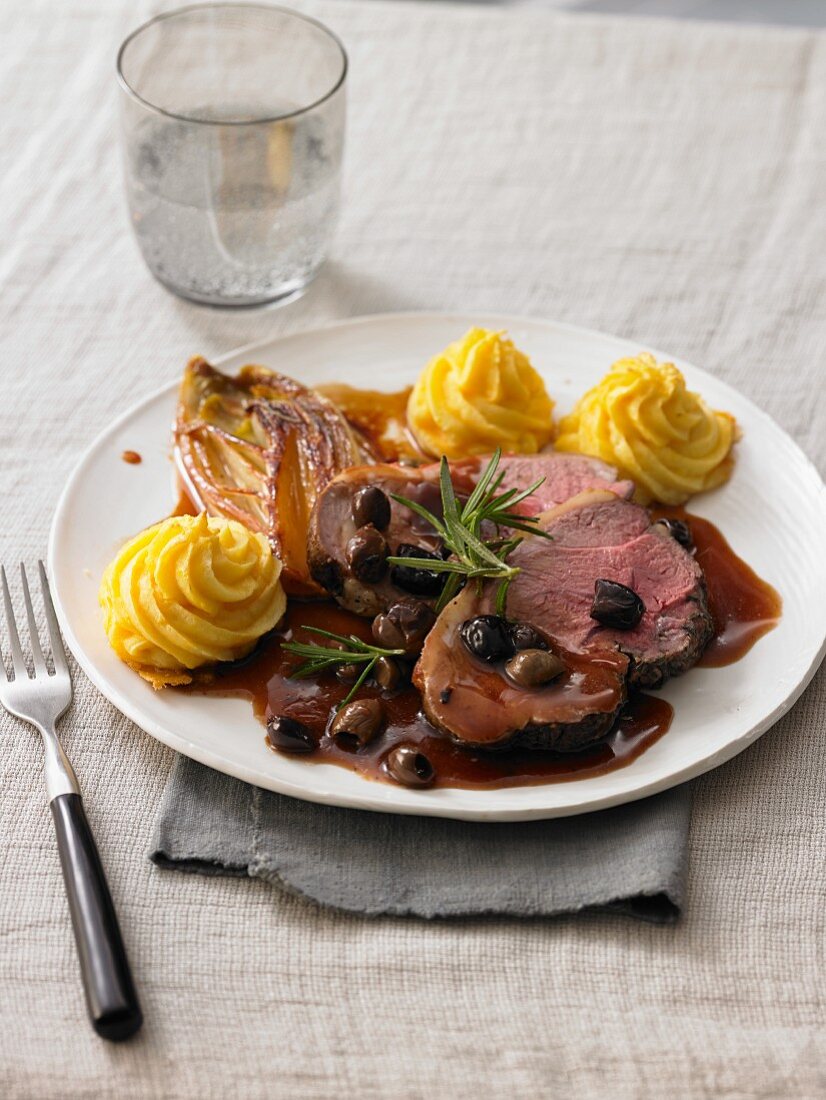 Roast beef with a red wine and olive sauce, Duchess potatoes and chicory