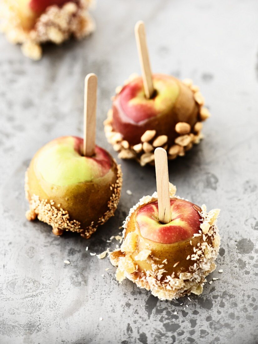 Toffee apples with nuts, sesames seeds and coconut