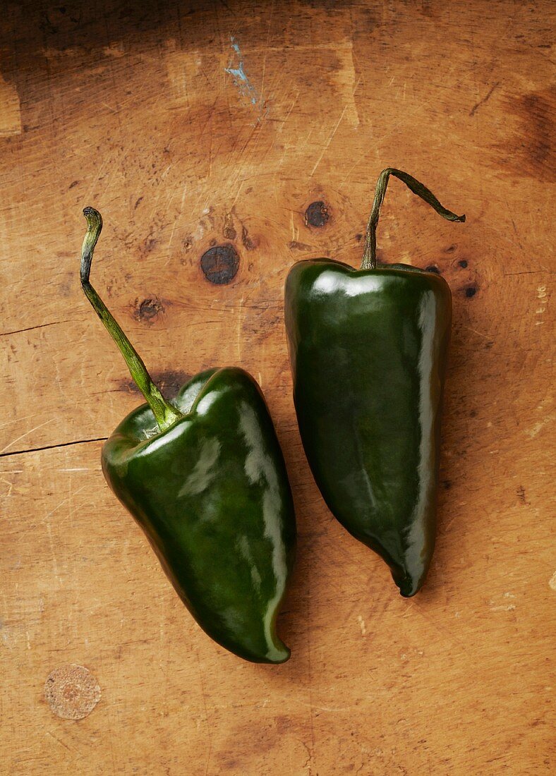 Two fresh poblano chilli peppers (seen from above)