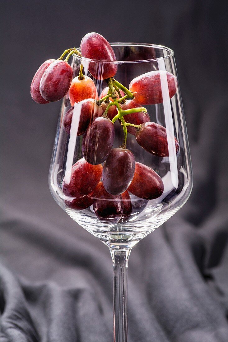 Rote Trauben im Weinglas