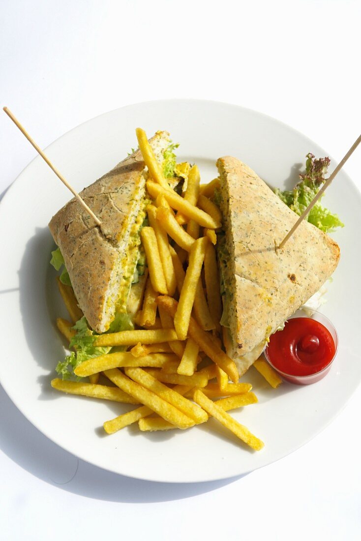 A club sandwich with chips and ketchup on a plate