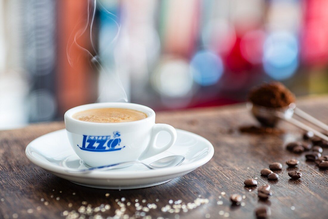 Espressotasse, Zucker, Kaffeebohnen und Kaffeepulver auf Holztisch