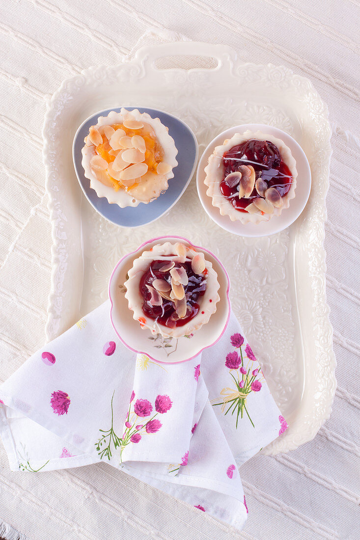 Cherry and peach tartlets on a tray (seen from above)