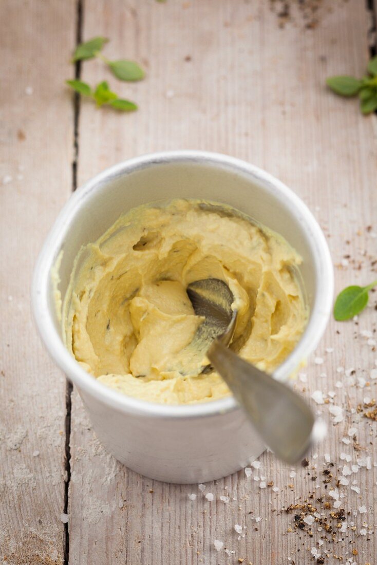 A bowl of mustard with a spoon
