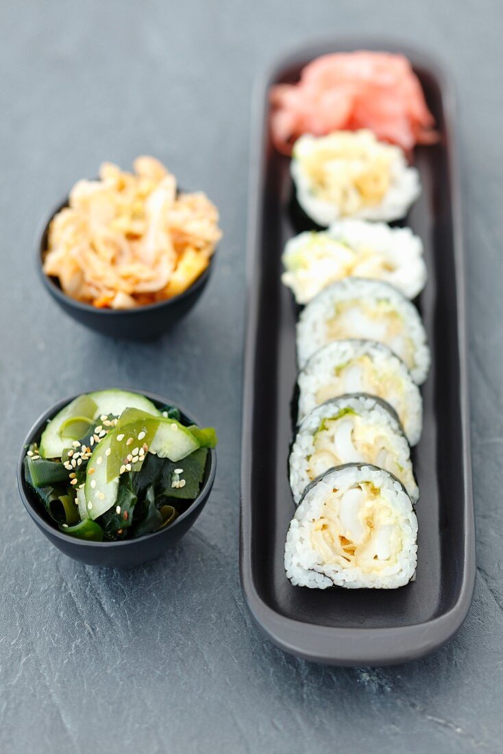 Sushi with squid in tempura, wakame and kimchi salads