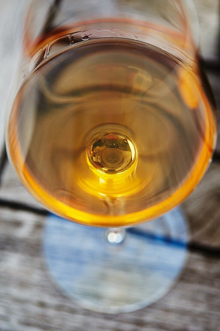 Naturbelassener (ungefilterter) biologischer Wein im Glas, orangefarbener Wein im Glas