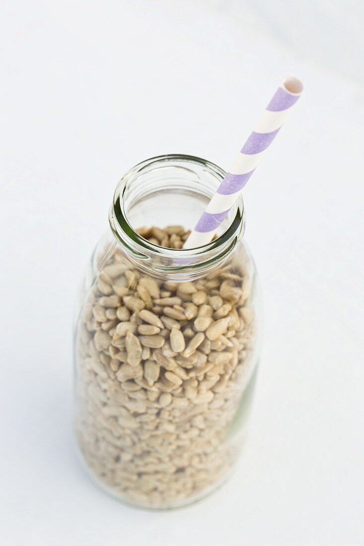 Sunflower seeds in a milk bottle with a straw