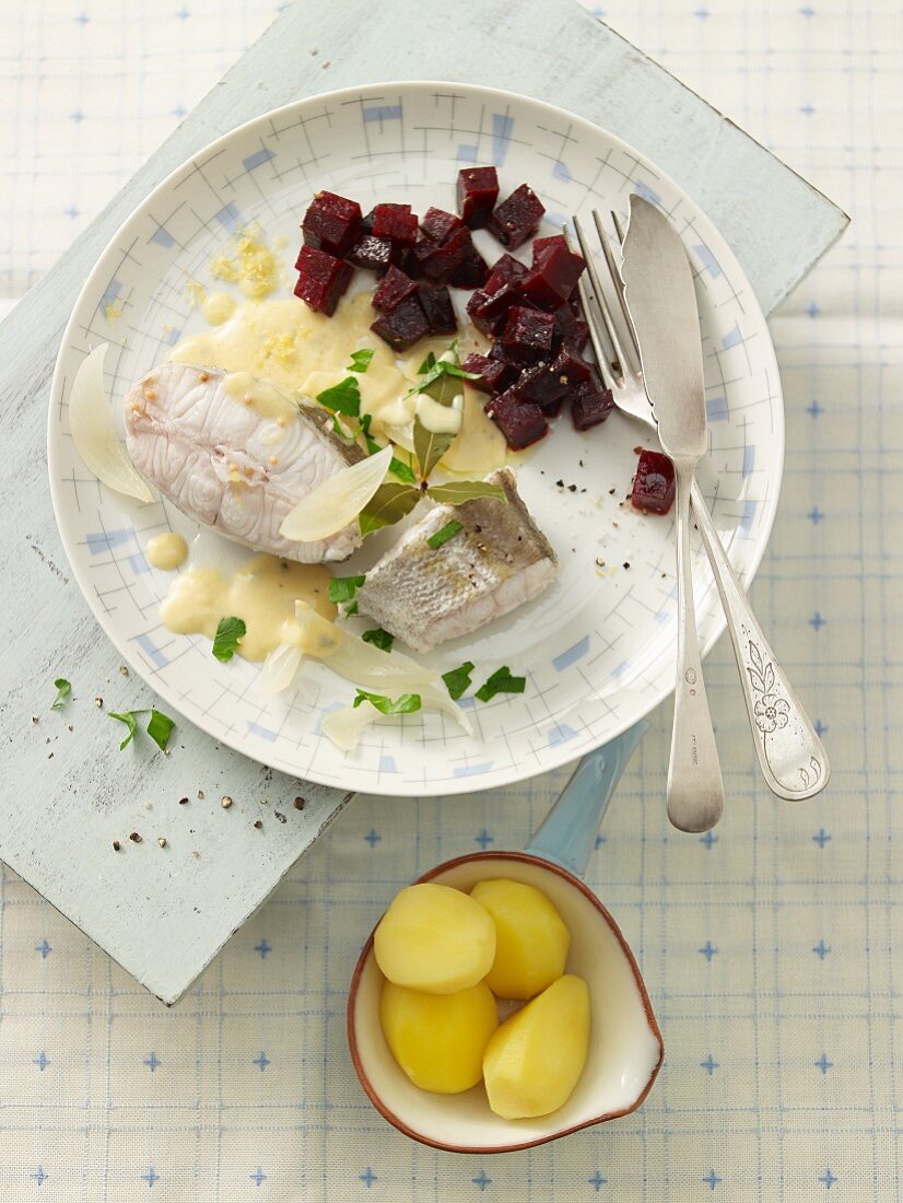 Poached cod with a butter and mustard sauce, beetroot and salted potatoes
