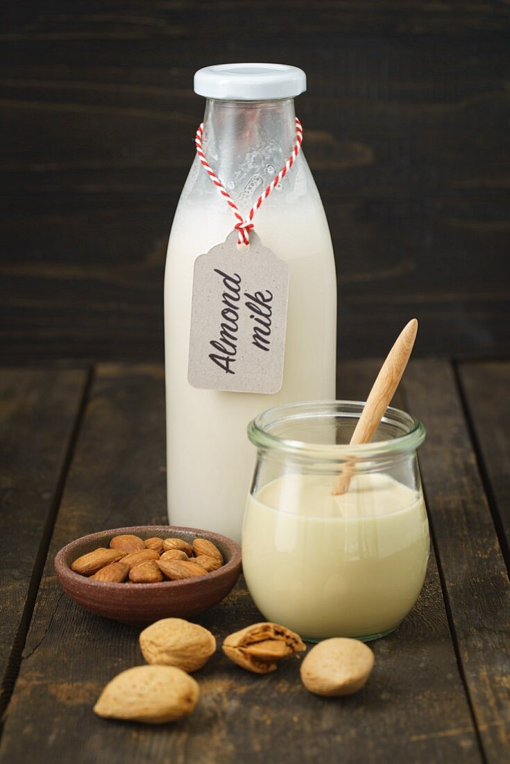 A jar of almond mousse and almond milk in a glass bottle