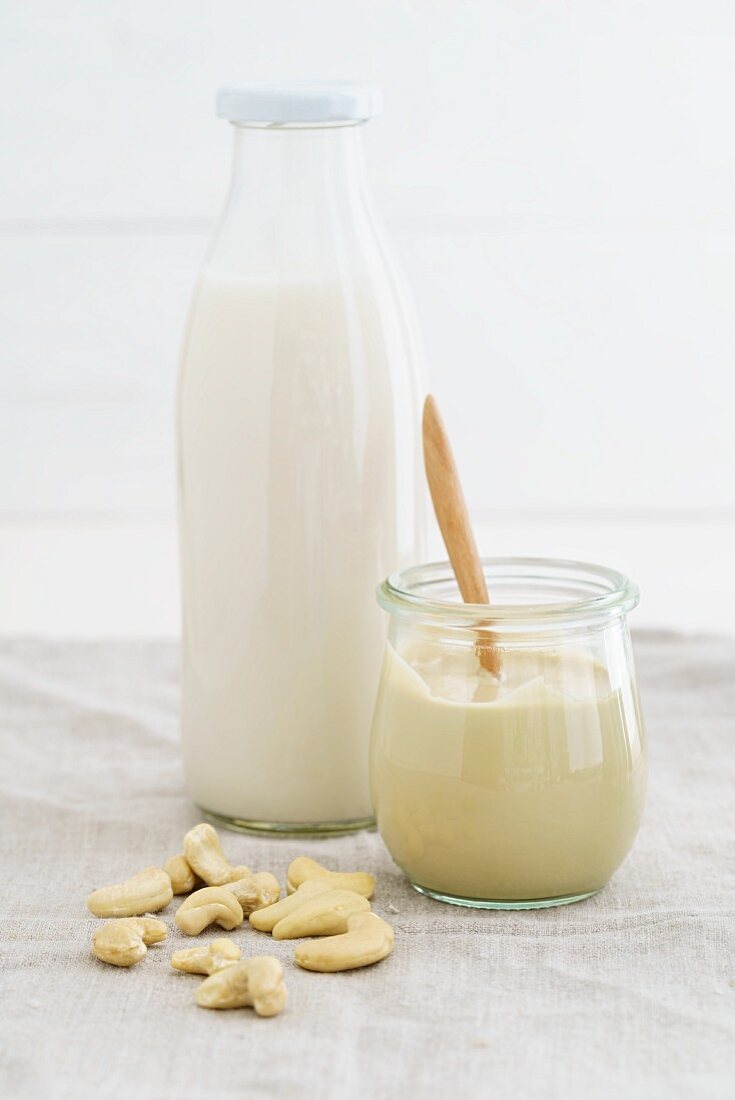 A jar of cashew nut mousse and cashew nut milk in a glass bottle