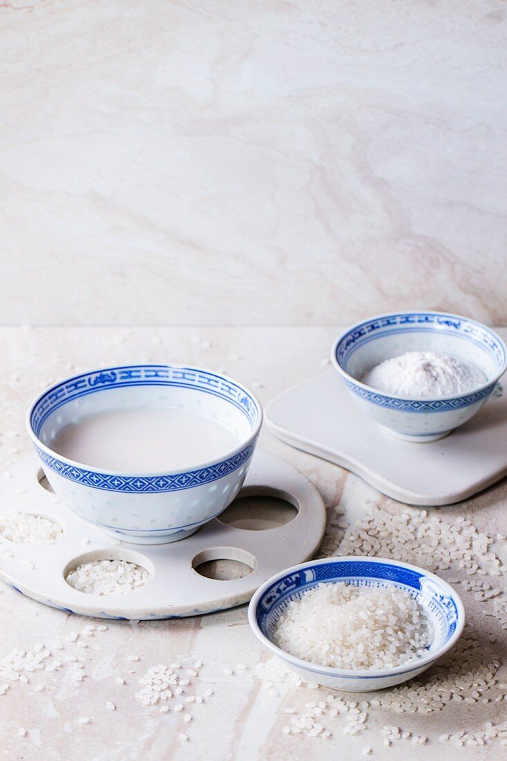 Reisdrink, Reismehl und Reiskörner in Schalen auf Marmorfläche