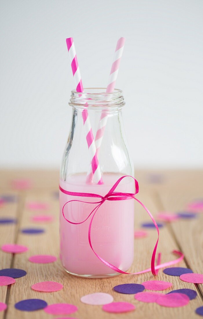 A strawberry drink in a bottle with straws