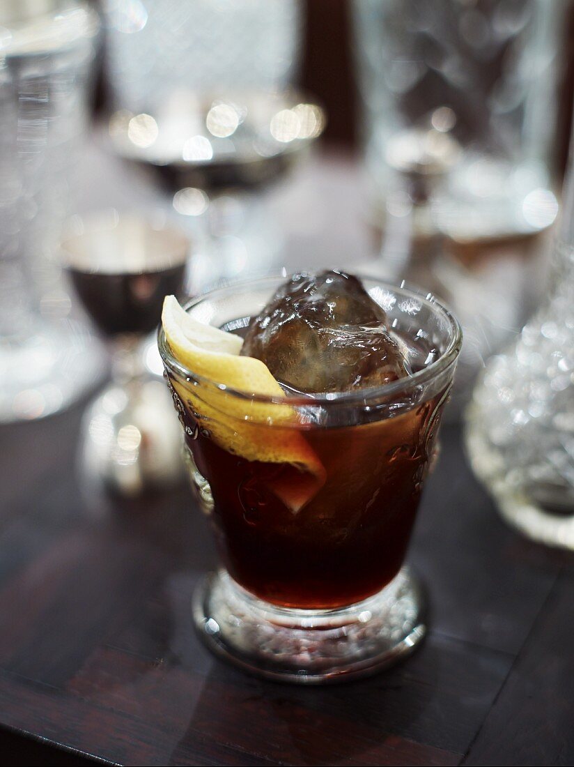A glass of cola with ice and a slice of lemon