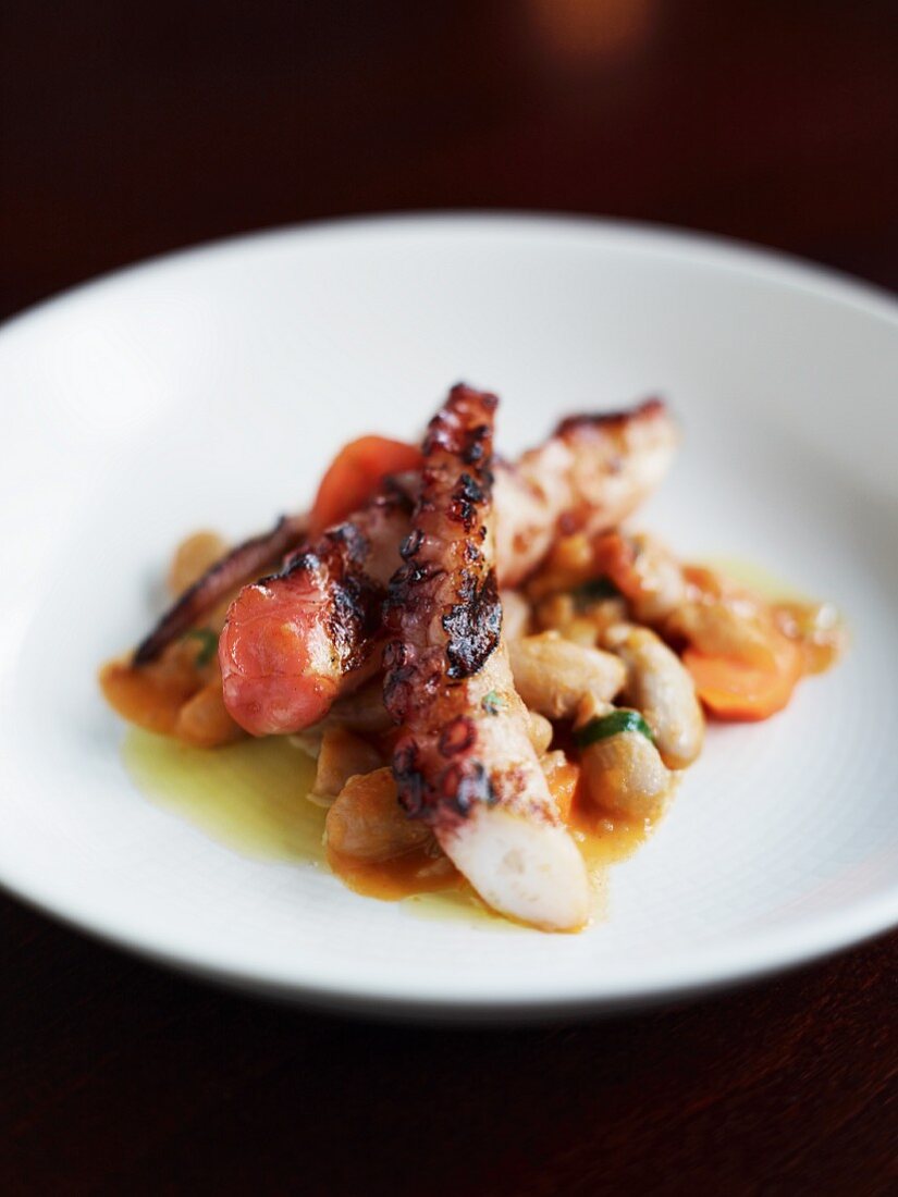 Fried octopus on a bed of beans and tomatoes