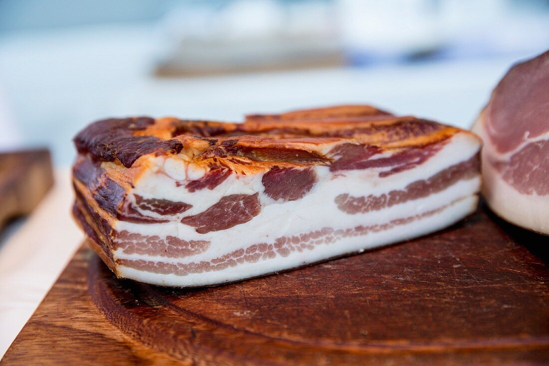 A piece of smoked bacon on a wooden board