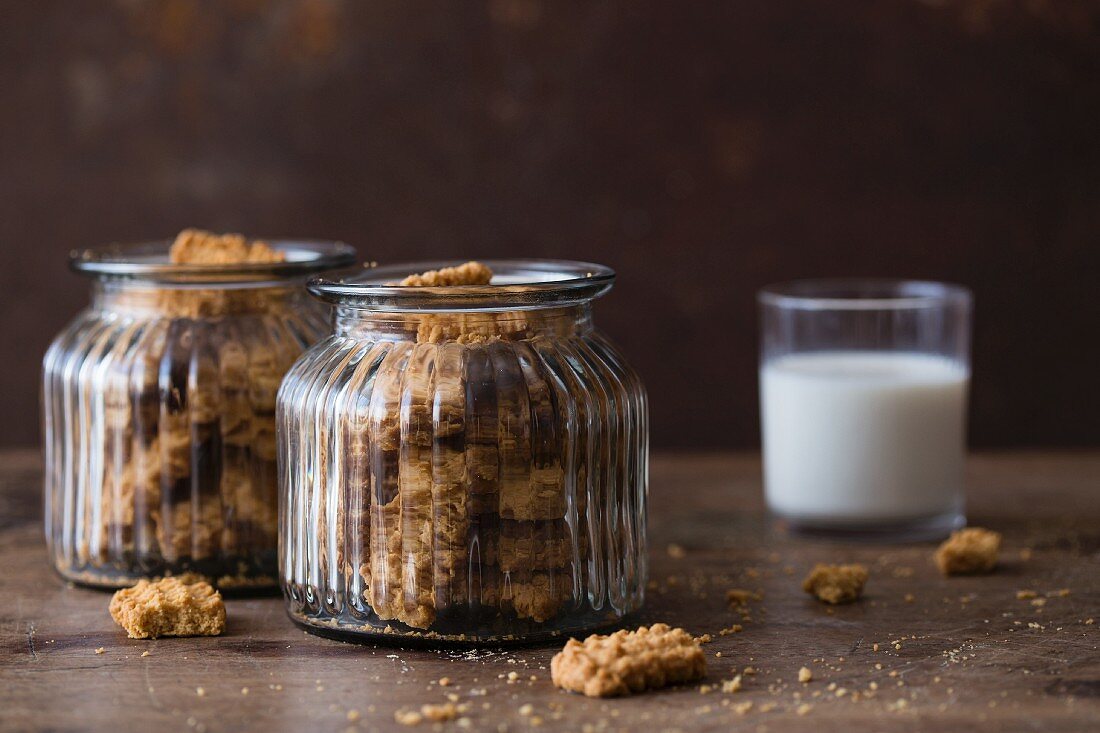 Cookies in glass jars with a glass of milk