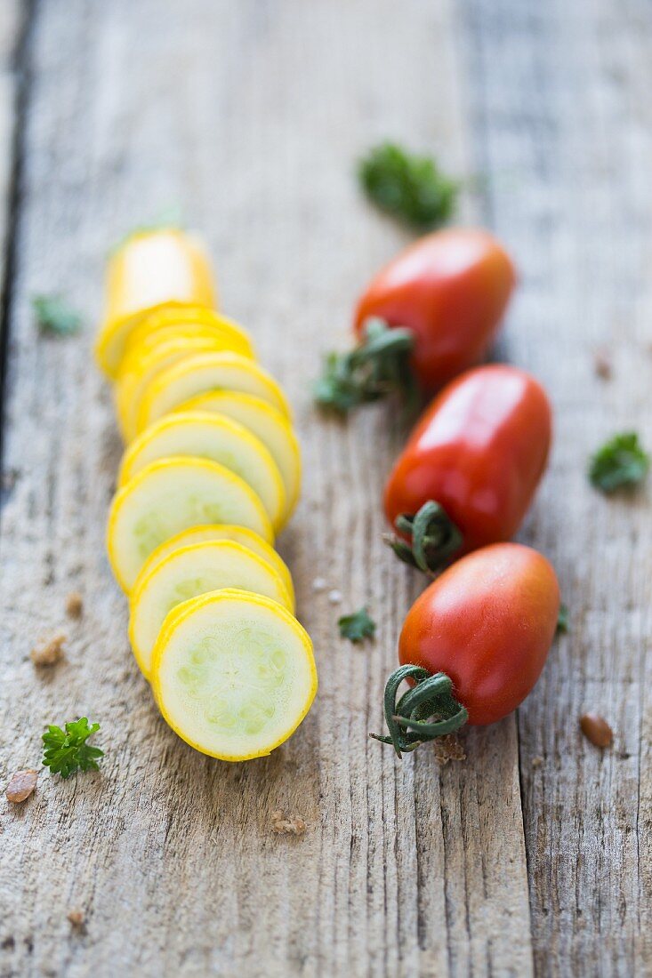 Zucchinischeiben und Tomaten auf Holzuntergrund