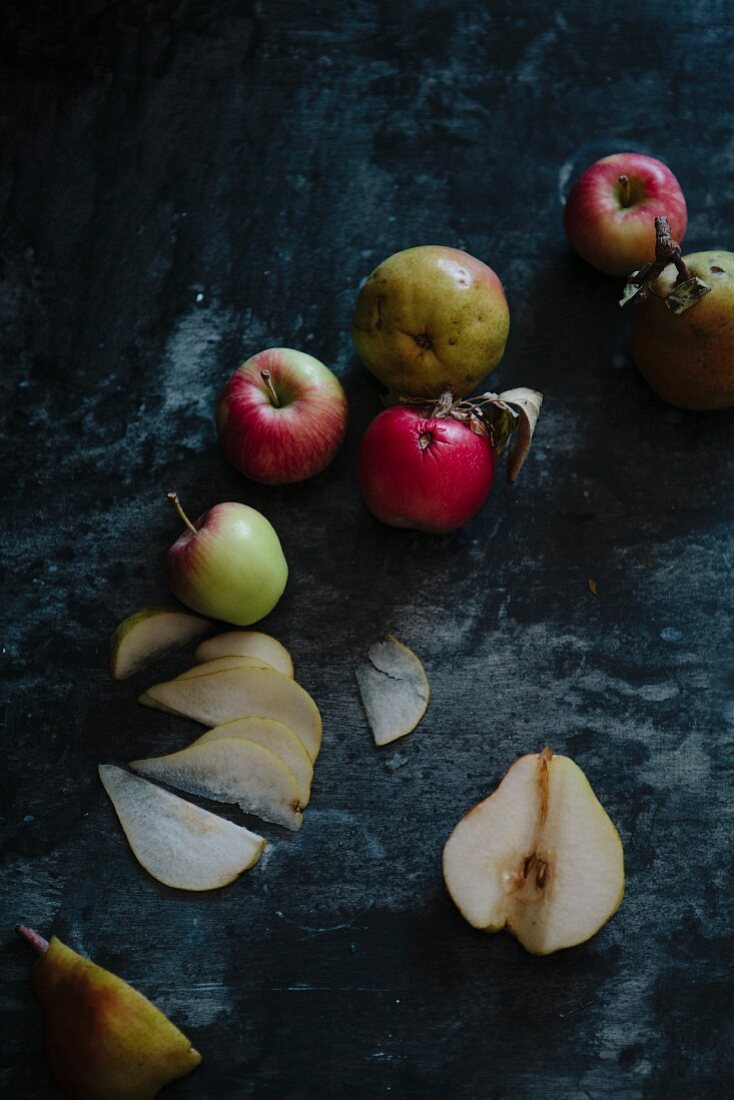Äpfel und Birnen auf dunklem Hintergrund