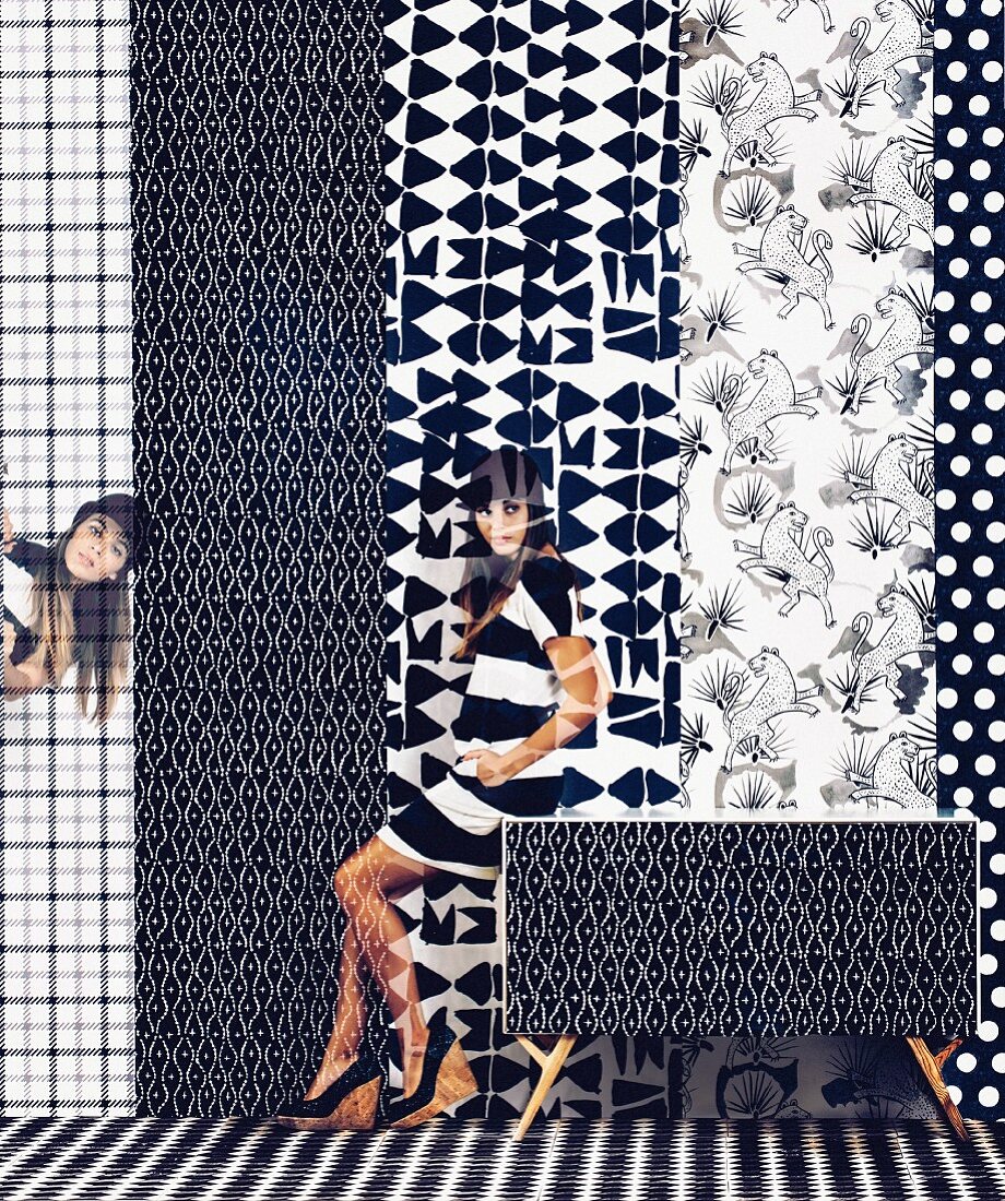 Pattern mix in black and white: Young woman in front of different tracks of wallpaper with different graphic motifs
