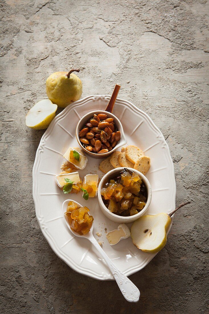 Cheese canapés with a spicy pear compote served with rosemary almonds and bread crisps