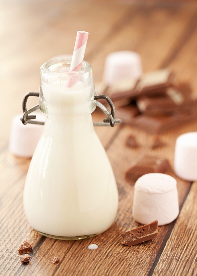 Eine kleine Flasche Milch mit Marshmallows und Schokolade