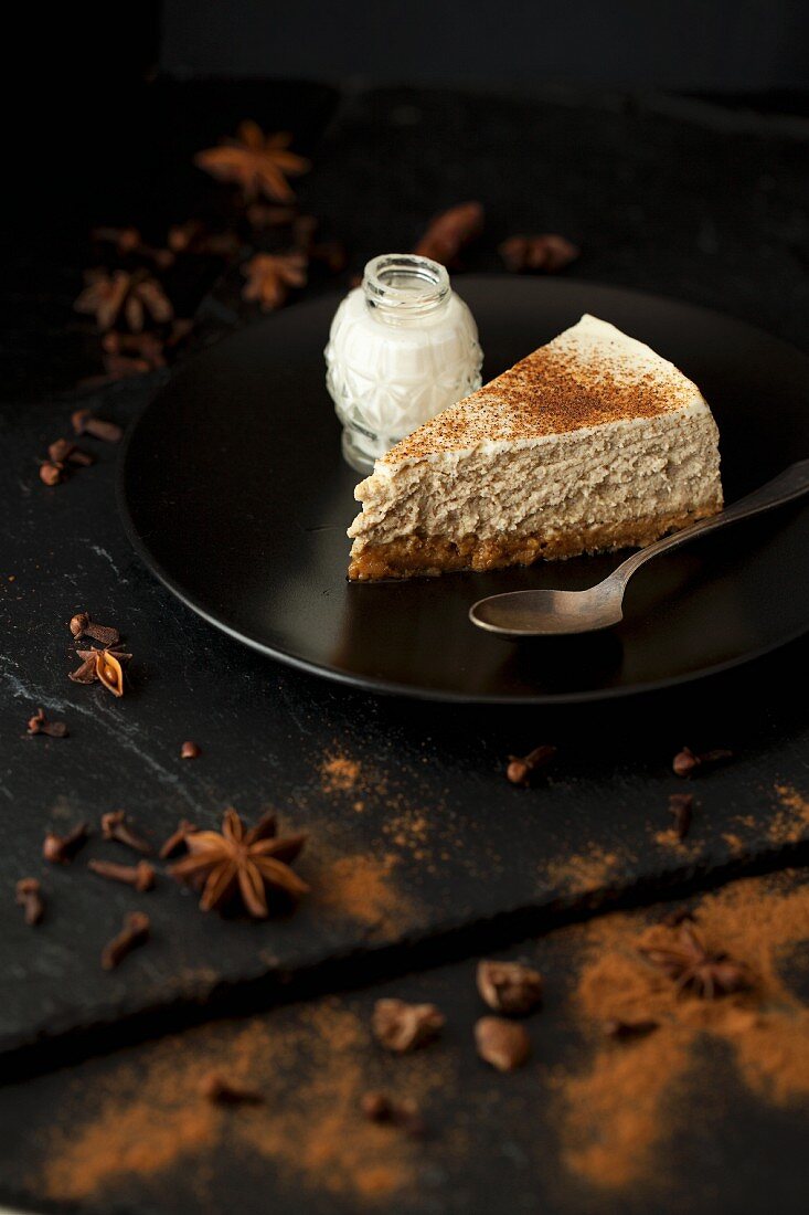 A slice of cheesecake with star anise, cinnamon and cloves