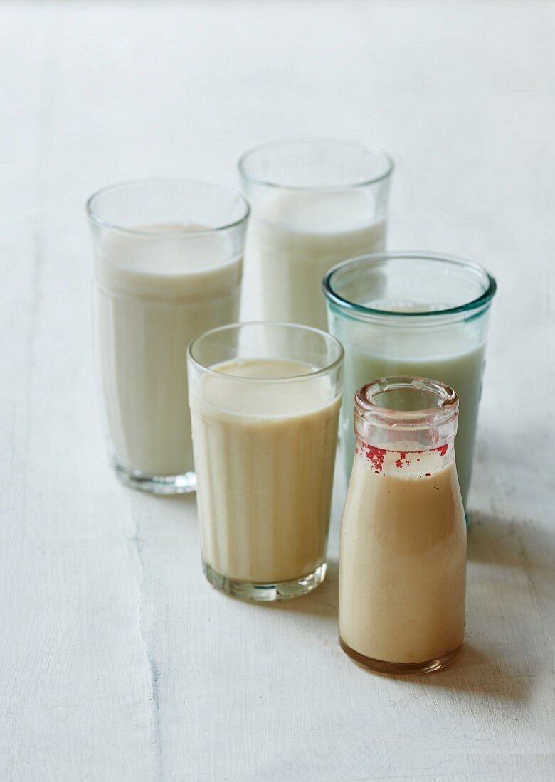 Various types of vegan milk in glasses and bottles