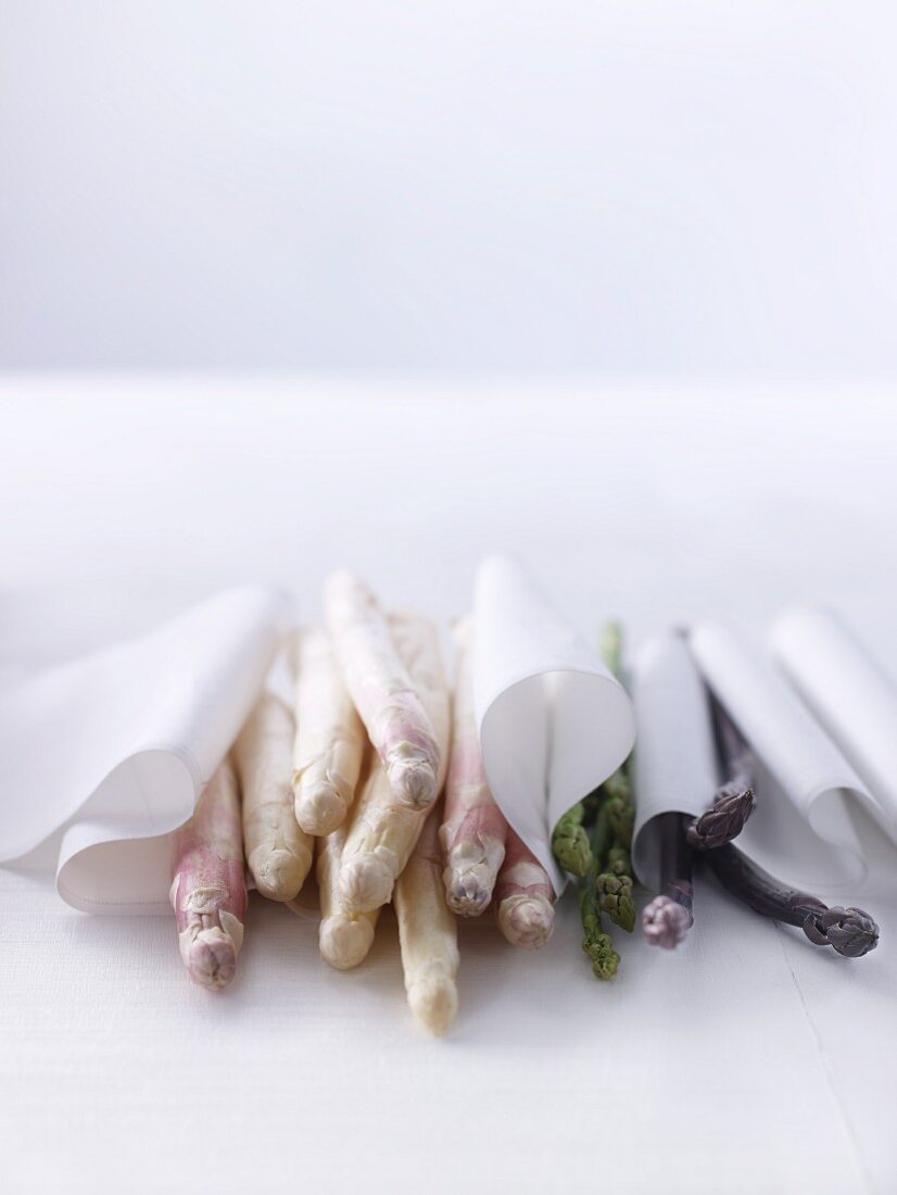 White green and purple asparagus wrapped in cloths