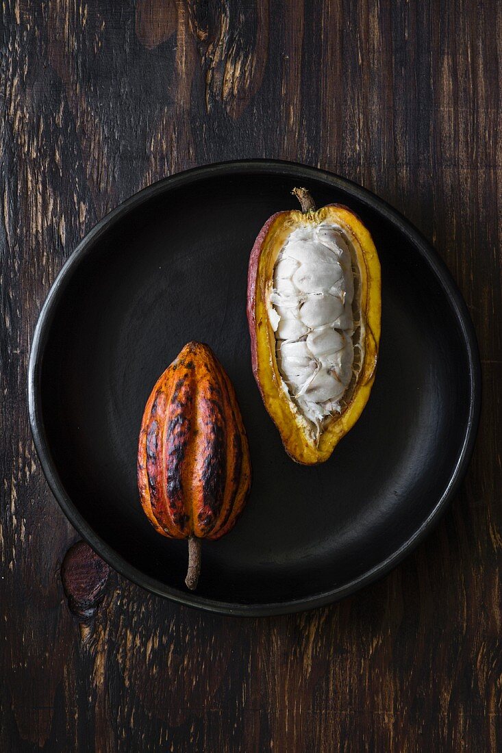Two cacao pods, whole and sliced open (seen from above)