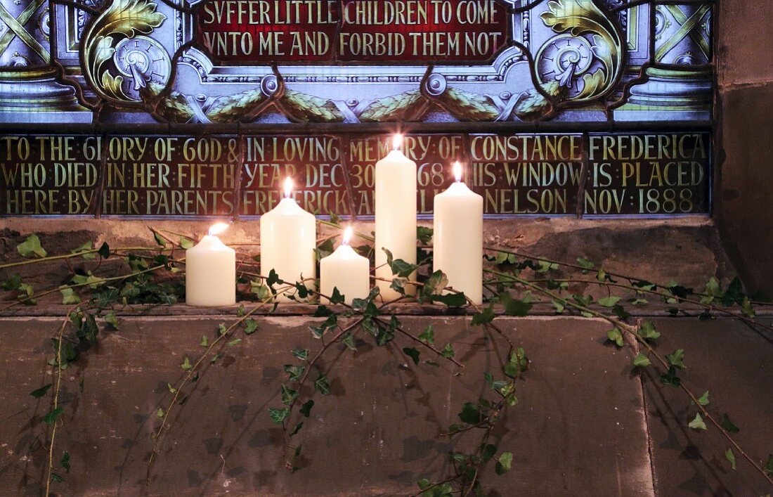 Candles burning in front of a gravestone