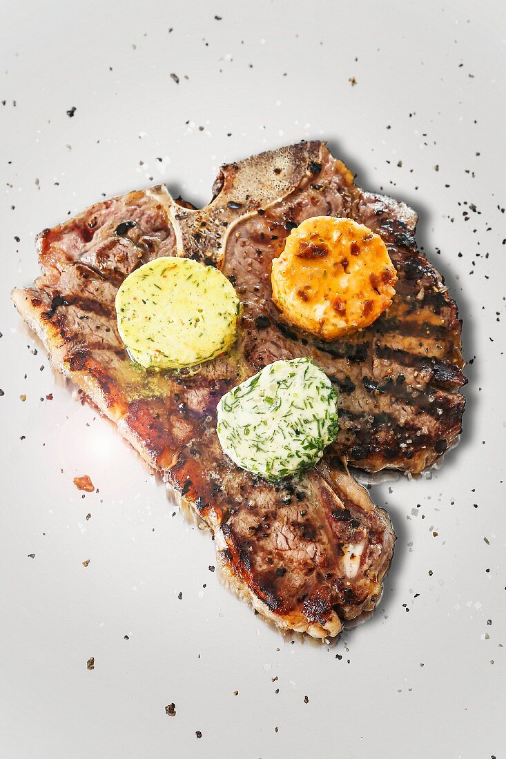 A T-bone steak with three types of herb butter
