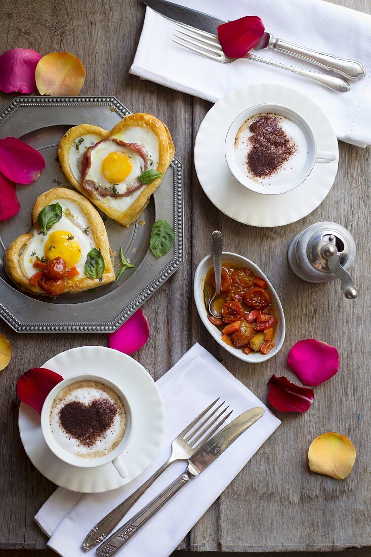 Blätterteigherzen mit Ei und Speck, dazu geschmorte Kirschtomaten und ein Cappuccino mit Kakaoherz