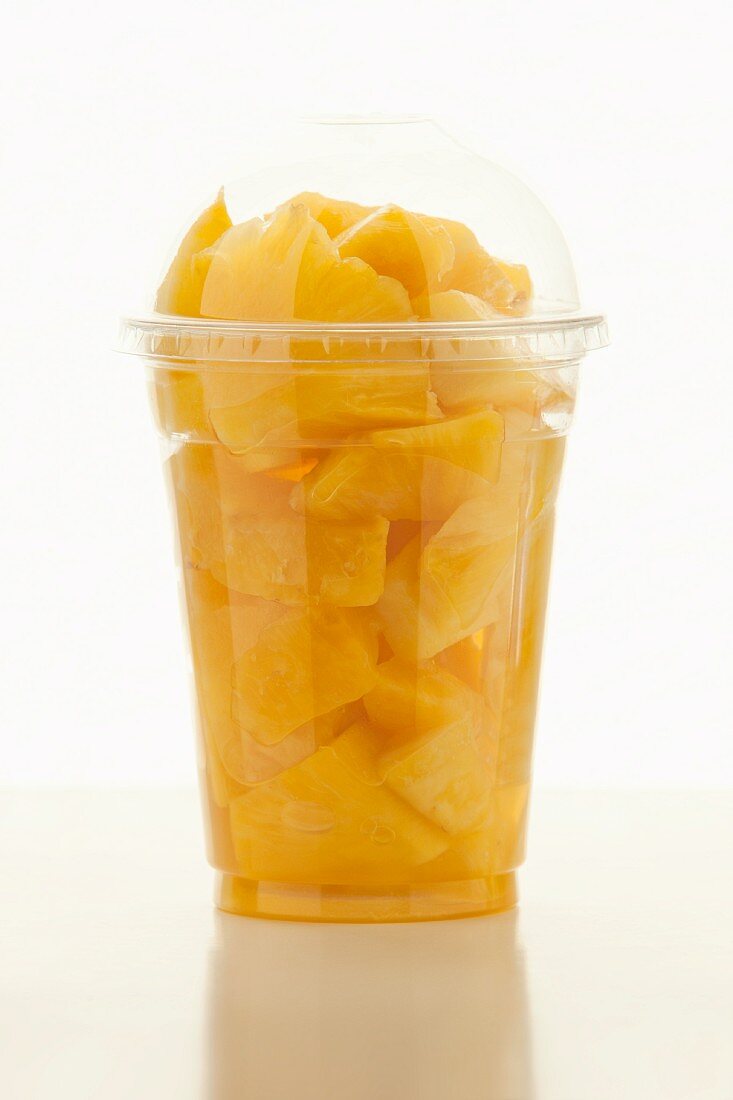 Sliced pineapple in a plastic cup