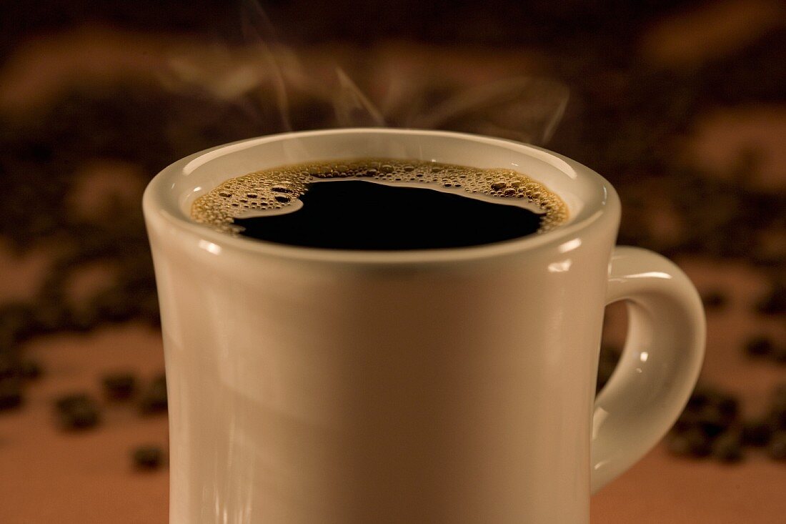 A steaming hot mug of black coffee