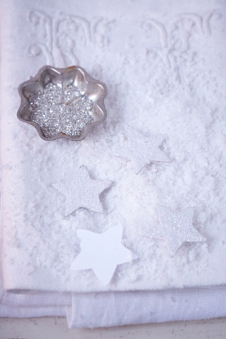 Table decorations with stars and silver glitter in a star-shaped tin