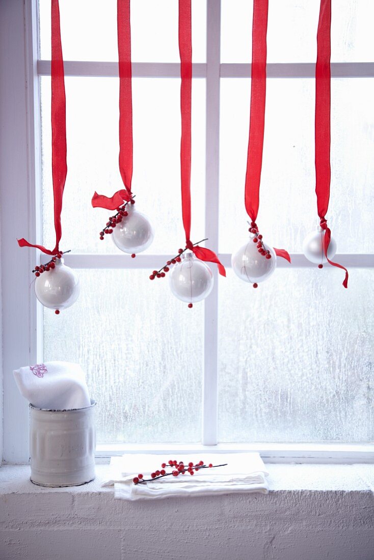 Christmas window decorations with red-and-white decorated Christmas baubles
