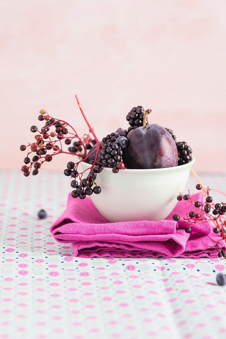 Damsons, elderberries, blackberries and blueberries in a bowl