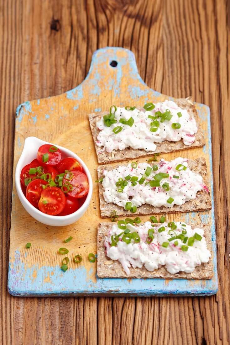 Crisp bread with cottage cheese, radishes and spring onions served with tomato salad