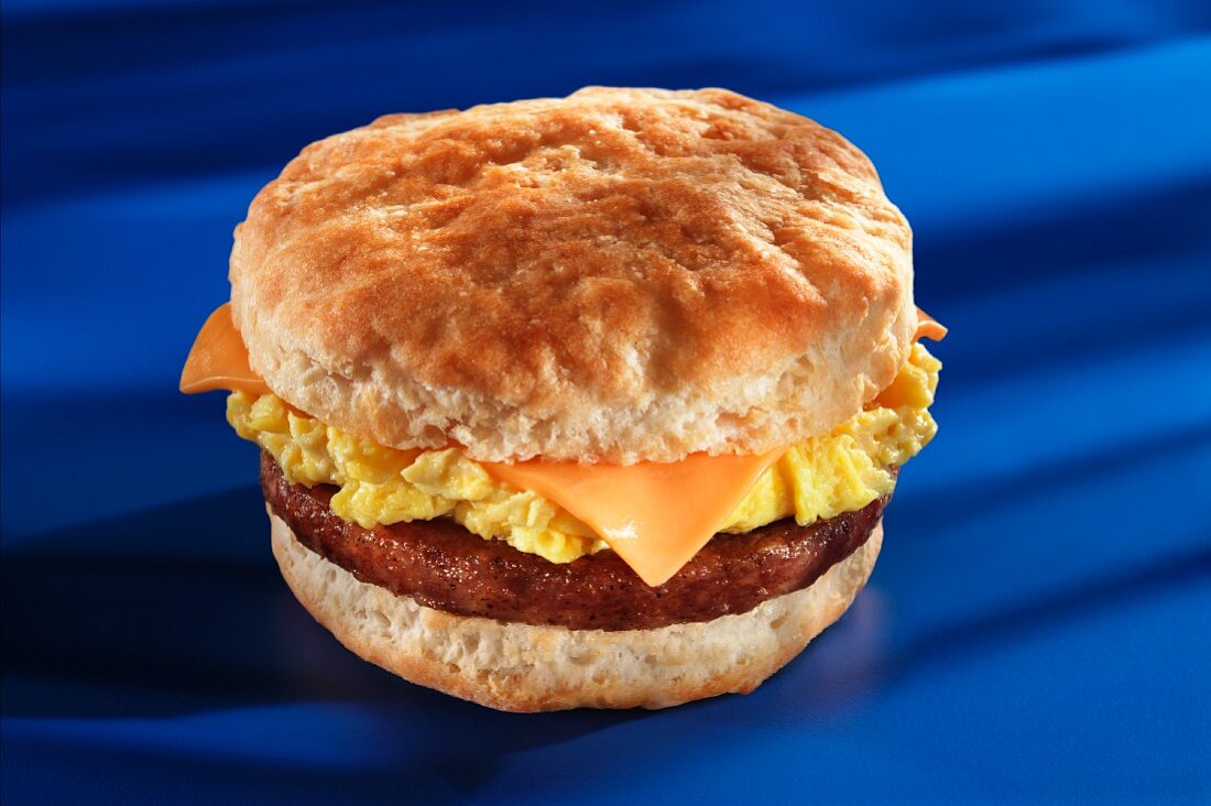 Fried sausage, cheese and scrambled egg on an American biscuit