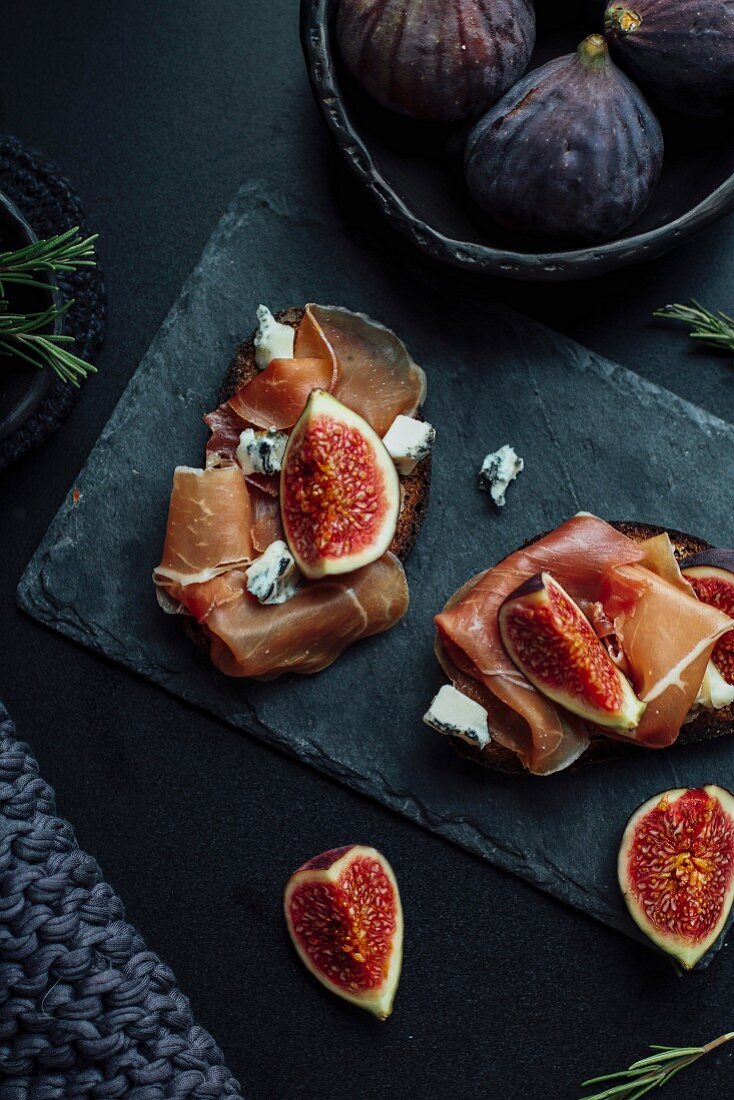 Open sandwiches topped with raw ham, figs and blue cheese