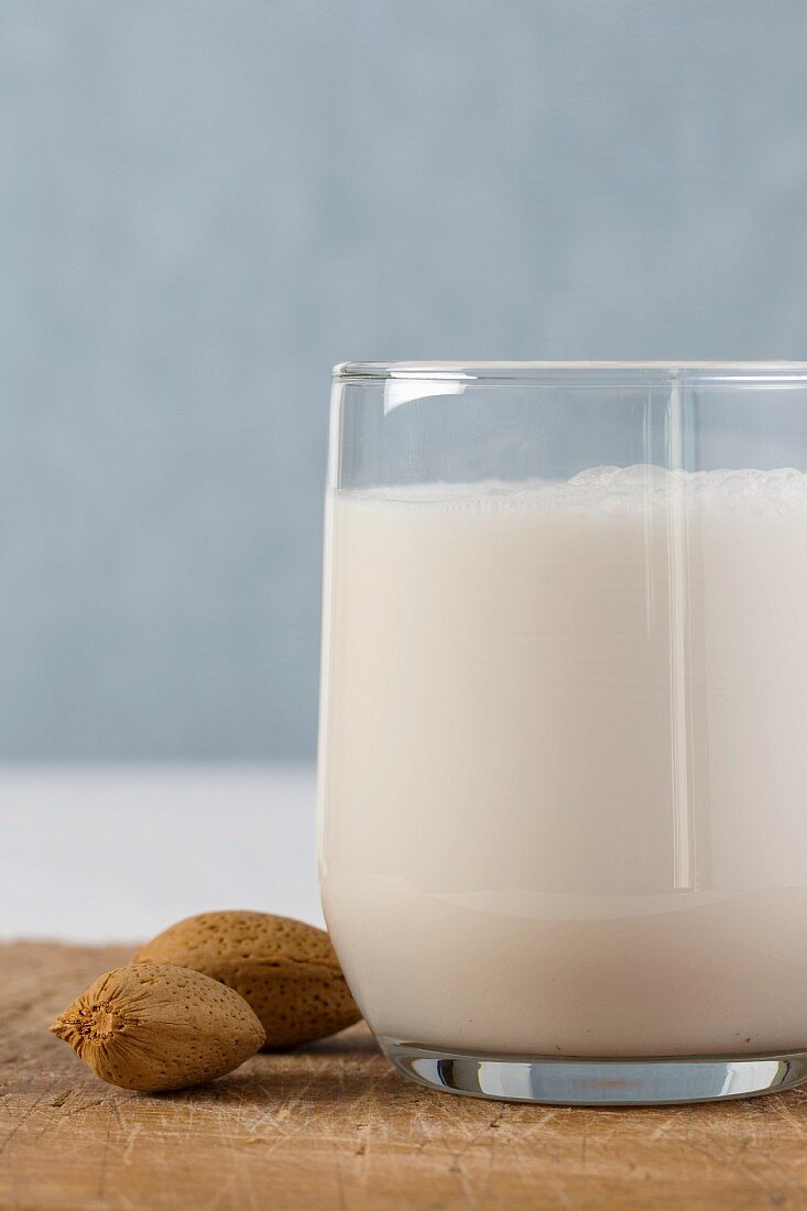 A glass of almond milk and whole almonds