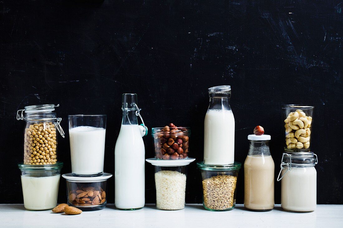 Vegane Milch und Zutaten vor schwarzem Hintergrund
