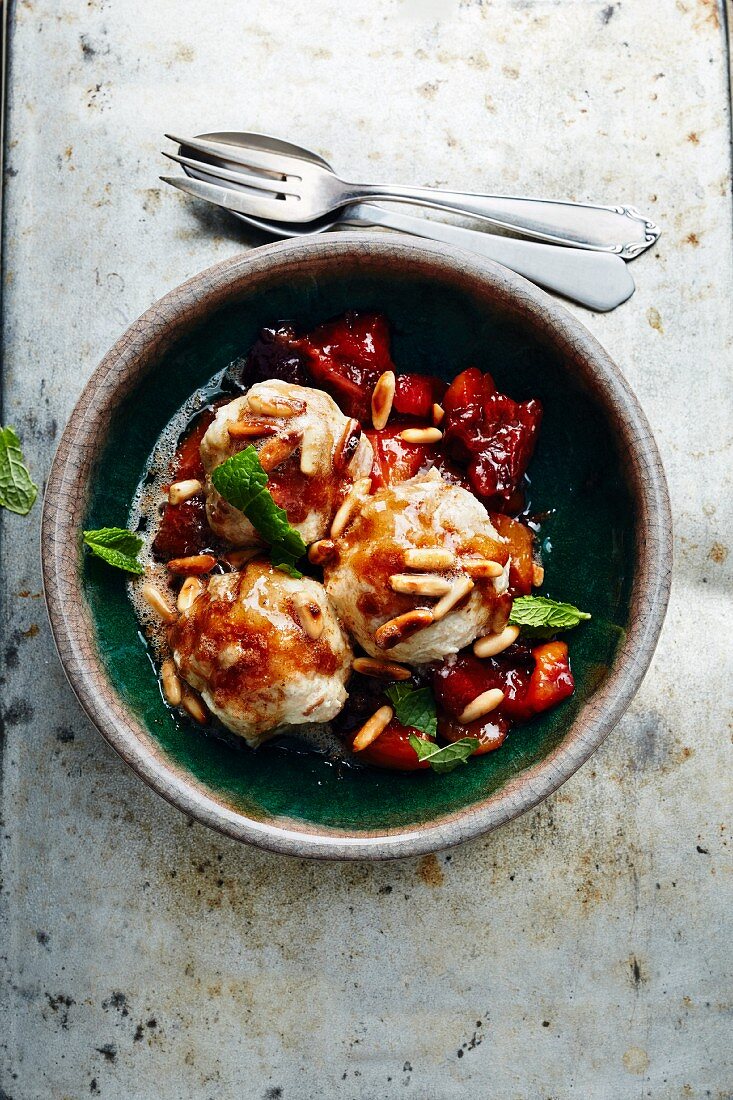 Unleavened bread dumplings with a plum and apricot sauce and pine nuts (Turkey)